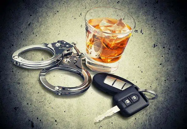 Handcuff, car keys and whiskey glass