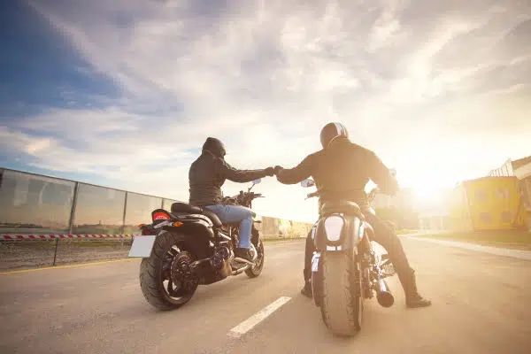 Two motorcyclist fist bumping each other