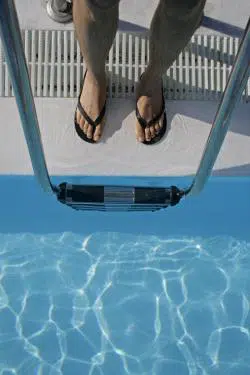 Overhead view of someone about to climb down the ladder into the pool