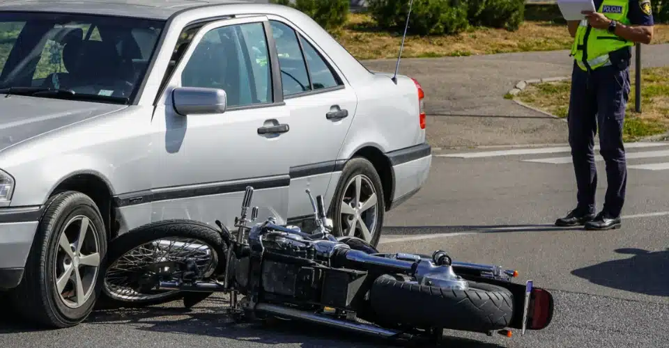 A motorcycle on the ground after a car pulled out in front of it