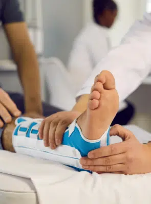 Right foot in an aircast with multiple hands tending to it