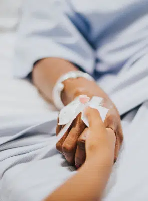 holding the hand of a person in the hospital