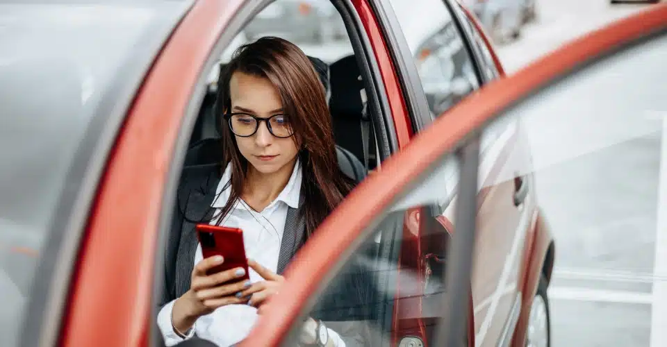 A woman in a parked car documenting a parking lot accident