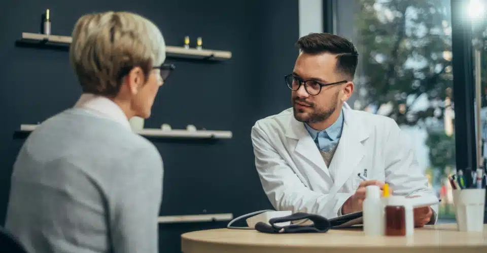 A woman discussing migraine pain with a doctor