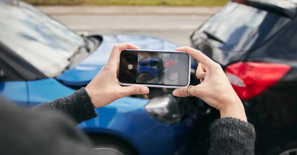 A cell phone being used to photograph the scene of an accident