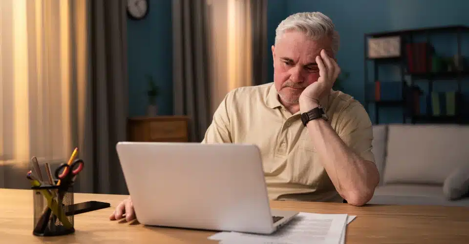 A man reading on a laptop computer