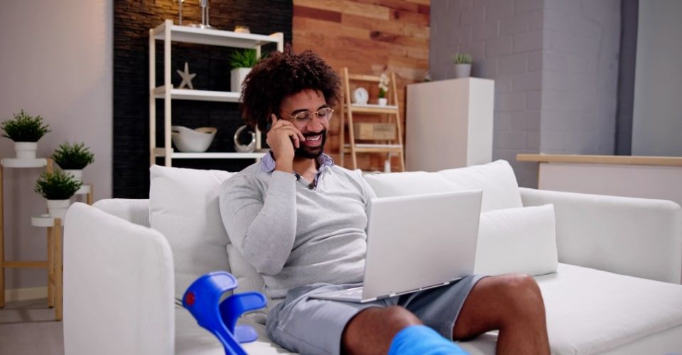 An injured person making a phone call while researching online