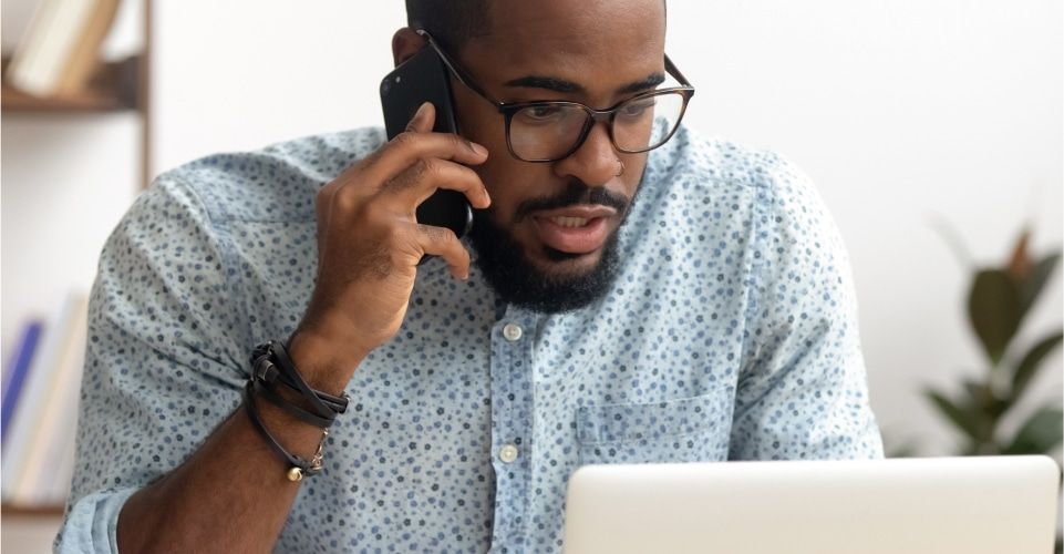 Man on phone looking concerned, illustrating distracted driving and potential accident liability.