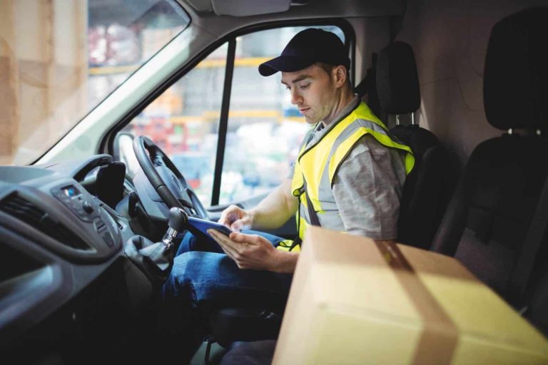 Delivery truck driver using tablet after a collision, seeking legal guidance in Louisville, KY.