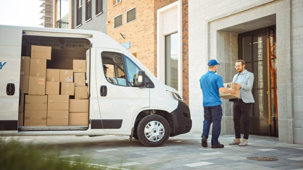 Delivery truck with driver delivering packages, illustrating delivery truck accident liability.