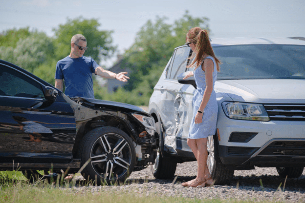 Damaged vehicles and people discussing car accident aftermath.